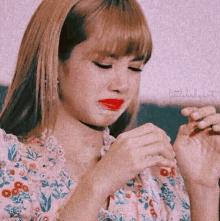 a close up of a woman 's face with red lipstick and a pink background .