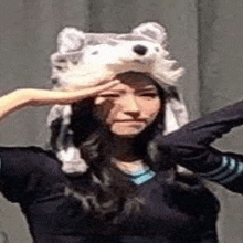 a woman wearing a husky hat is making a salute .