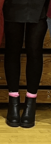 a person wearing black tights and pink socks