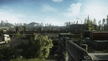 a person is holding a gun in a video game while looking out over a city .