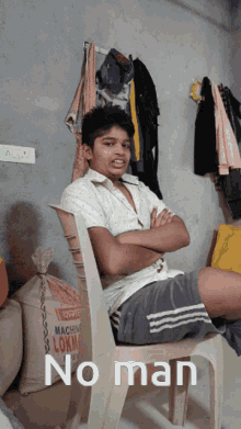 a young boy sits in a chair with his arms crossed and a bag of machine lokma on the floor behind him