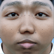 a close up of a young man 's face with a piercing in his lip