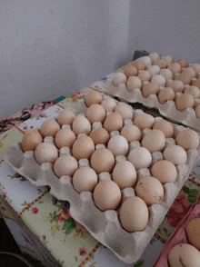 two trays of eggs on a table with flowers on it