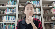 a woman stands in front of a bookshelf with a book titled ' a brief history of the world '