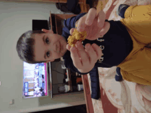 a little boy is holding a cookie in front of a tv that says ' istanbul ' on the screen