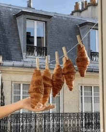 three croissants are hanging on a clothes line outside