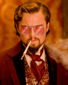 a man in a red suit and tie is smoking a cigarette