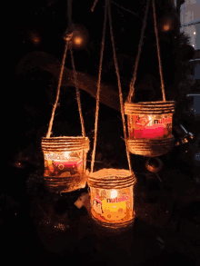 three candles made out of cans of nutella are hanging from a rope