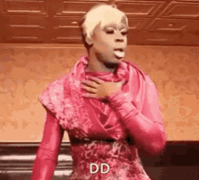 a drag queen in a pink dress is holding her chest .