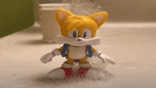 a toy of tails from sonic the hedgehog is standing in the water