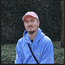 a man wearing a pink hat and a blue hoodie with michi on it