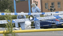 a blue car is parked in a parking lot behind a yellow tape that says ' emergency hot rescue ' on it