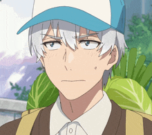 a man with white hair and a blue hat is standing in front of a bunch of lettuce