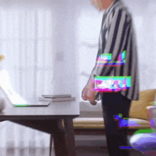 a man in a striped jacket is standing in front of a desk
