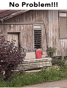 a man in a red shirt stands in front of a wooden house with the words no problem