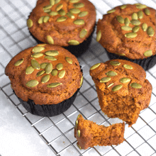 a muffin with a bite taken out of it is on a cooling rack