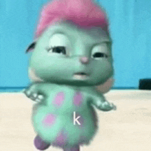 a cartoon character with pink hair is standing on a beach with the letter k on its chest .