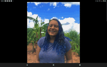 a woman with blue hair and glasses is smiling in front of a field