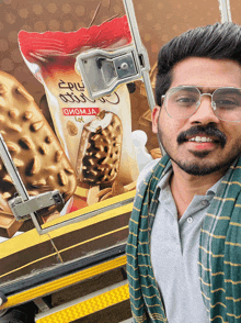 a man wearing glasses is standing in front of a bag of ice cream that says giom ja