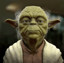 a close up of the face of yoda from star wars wearing a pink shirt and a white sweater .