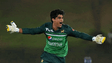 a man wearing a green pakistan jersey with pepsi written on it