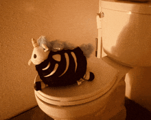 a stuffed animal is sitting on a toilet