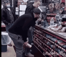 a group of men are standing in a convenience store and one of them is looking at a can of soda .