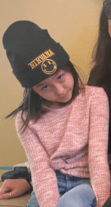 a girl wearing a beanie that says nirvana