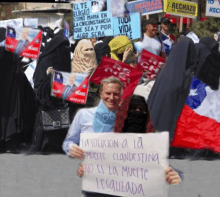 a man holding a sign that says " la solucion a la muerte clandestino "