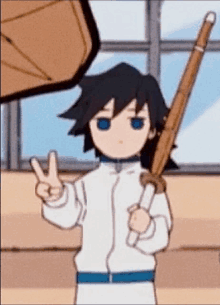 a boy is holding a sword and giving a peace sign .