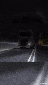 a scania truck is driving down a dark highway