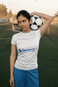 a woman holding a soccer ball on her head with a shirt that says levioz