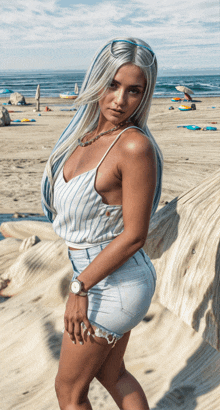 a woman in a striped top and shorts stands on a beach