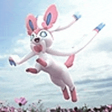 a pink and white pokemon is jumping in the air .