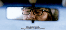 a man with glasses is looking at himself in a rear view mirror and says just get me home