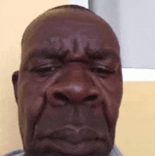 a close up of a man 's face with his eyes closed and a sad look on his face .