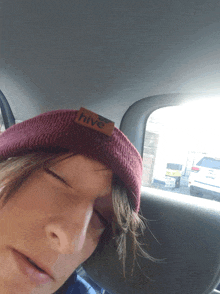 a person in a car wearing a hive beanie