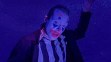 a man in a suit and tie is wearing a blue clown mask