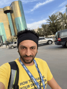 a man wearing a yellow shirt that says how to change your own mind on it