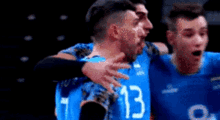 two volleyball players are hugging each other while wearing blue jerseys with the number 13 on them .