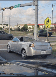 a silver car is parked on chris kelley ave near a traffic light