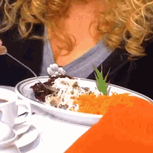 a woman is eating a plate of food with a carrot on it