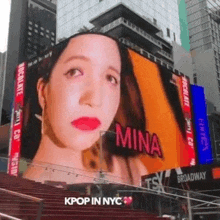 a large billboard with a picture of a woman 's face and the word mina on it .