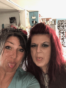 two women sticking their tongues out and one has a piercing