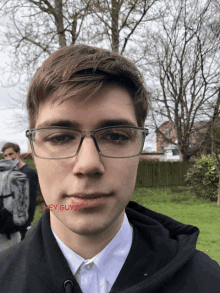 a young man wearing glasses has a red sticker on his face that says hey guys