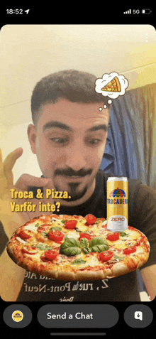 a man is holding a pizza next to a can of rocadera