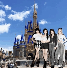 a group of girls pose in front of a castle