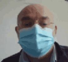 a bald man wearing a blue face mask with glasses .