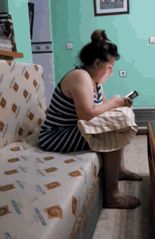 a woman sits on a couch looking at her phone with the word orthocare on it