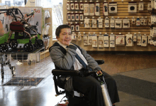 a young boy in a wheelchair in front of a nova sign